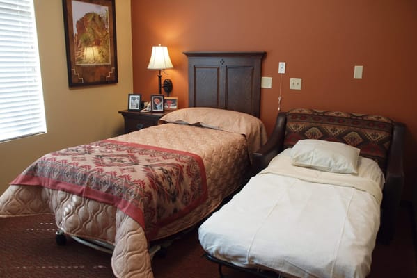 Two beds in a warmly decorated senior living bedroom