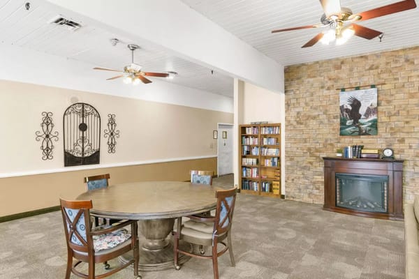 Cozy common area featuring a circular table, bookshelves, and a fireplace