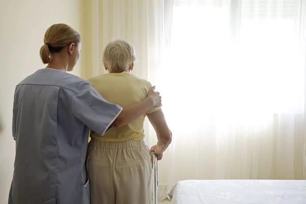 Caregiver assisting a resident in a bright room