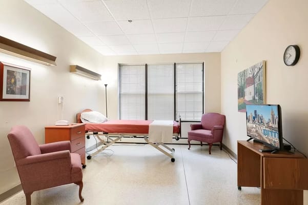 A private resident room with a hospital bed and seating