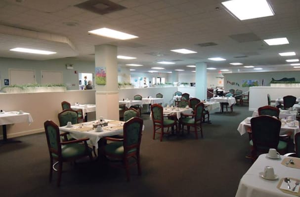 Bright dining area with tables set for residents.
