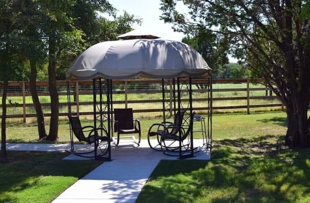 Outdoor gazebo with rocking chairs in a garden