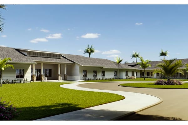 Exterior shot of Senior Living at the Greens with manicured lawns and palm trees