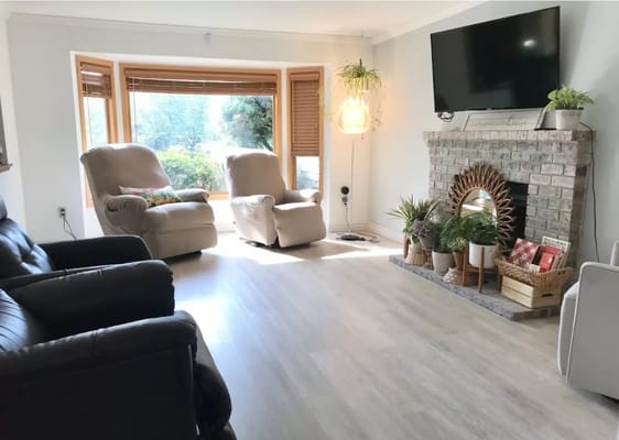 Bright living room with two recliners, a fireplace, and a TV
