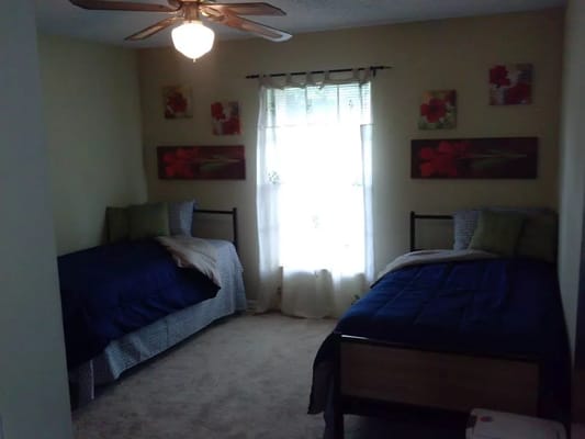 Bright bedroom with two beds and a window
