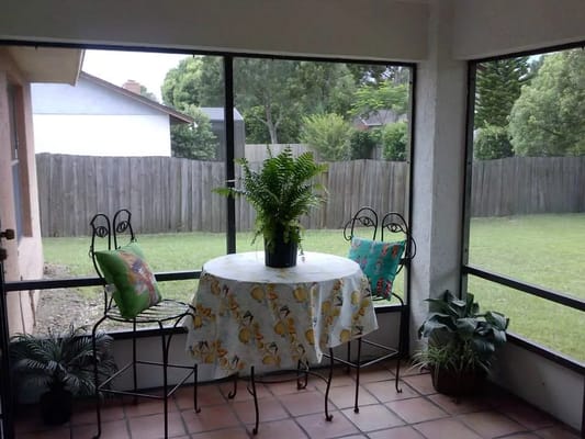 Cozy sunroom with table and plants.