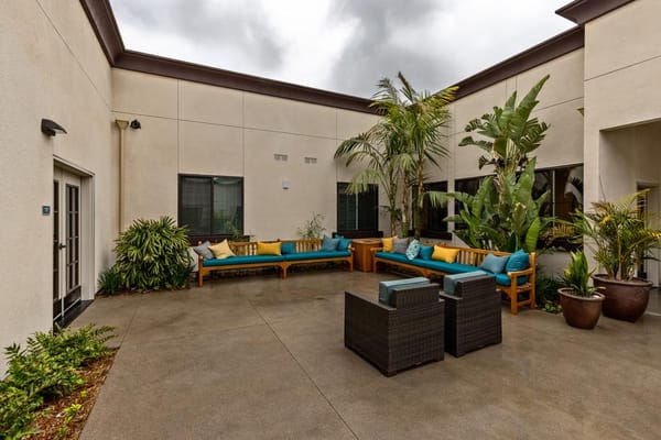 Outdoor courtyard with seating and plants at Serra Sol Memory Care
