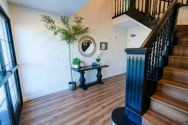 A well-decorated entrance hall with a plant and decorative table.