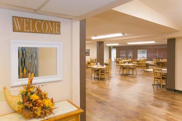 View of the dining room with a welcome sign and tables set for meals
