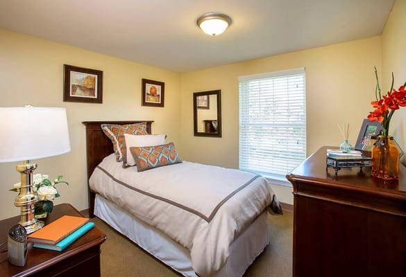 A well-decorated resident bedroom with a bed and natural light