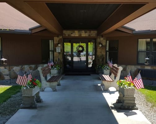 Welcoming entrance with benches and flower pots at Siemon's Heritage Personal Care Home