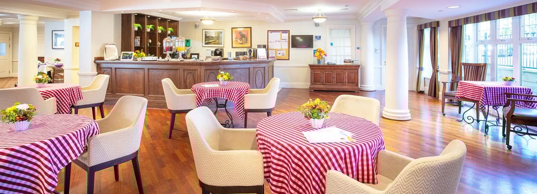 Comfortable seating and dining area in the common space with striped tables.