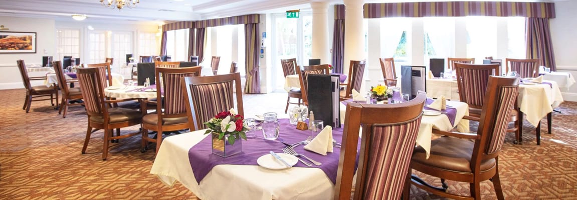 Well-set tables in the dining room with floral centerpieces.