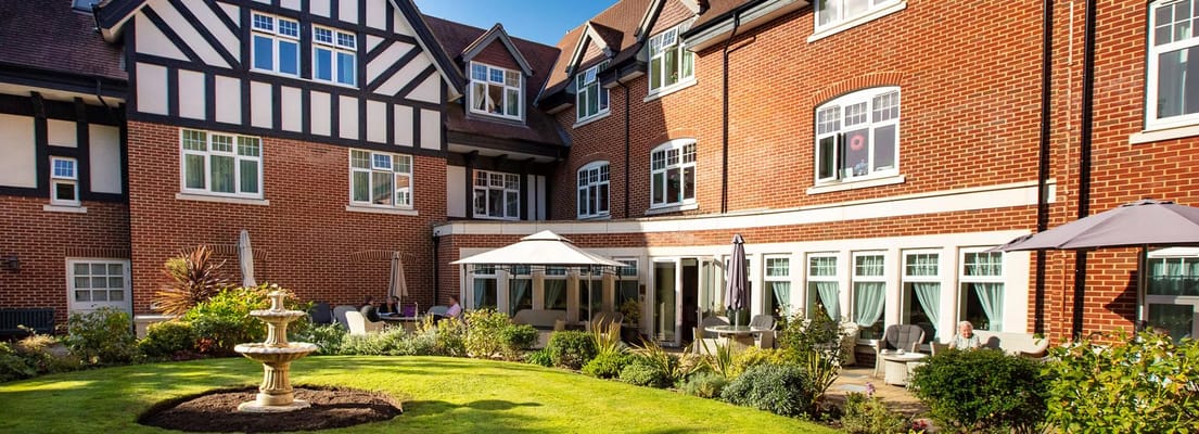 A garden area with a fountain and outdoor seating at Signature at Weybridge.