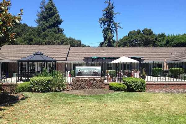 Exterior view of Canyon House with sign and patio area.