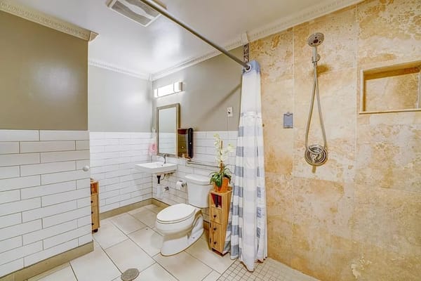 A modern bathroom with a shower and sink at Silver Oaks Memory Care.