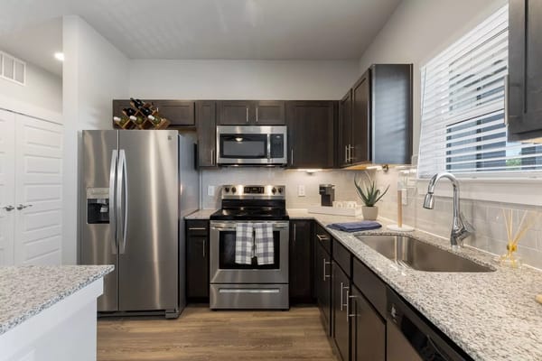 A sleek kitchen featuring stainless steel appliances and granite countertops.