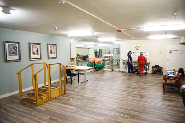 Therapy room with staff and equipment, showing activity