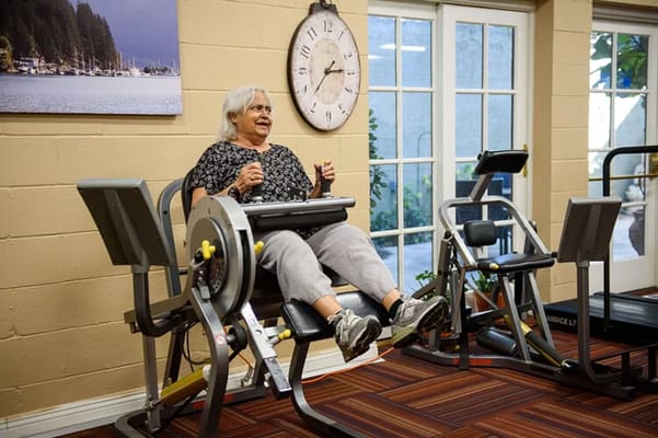 Resident using exercise equipment in a fitness area