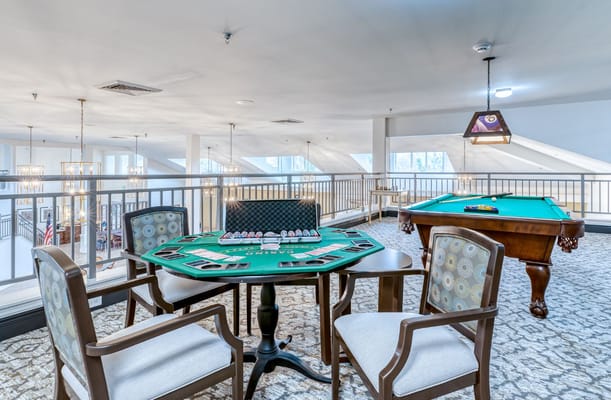 A gaming area featuring a poker table and pool table at Solstice Senior Living.