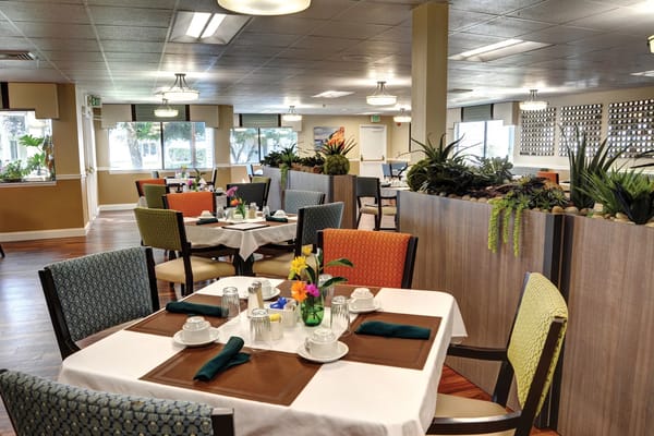 Dining area set for meals with floral centerpieces