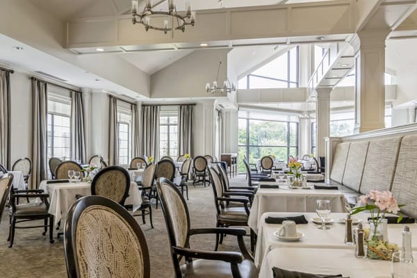 Elegant dining room with chairs and tables set for meals.