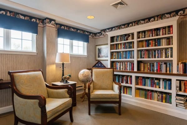 Library corner with two armchairs and bookshelves