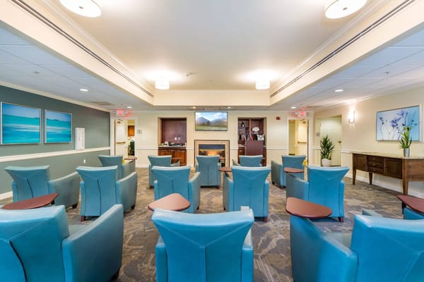 Lounge area with teal chairs and a fireplace