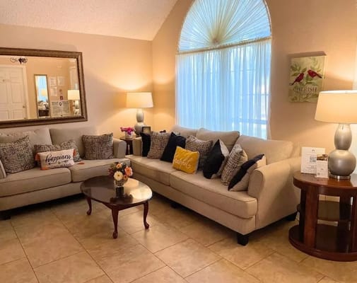 Cozy living room with beige sofas, decorative pillows, and a coffee table