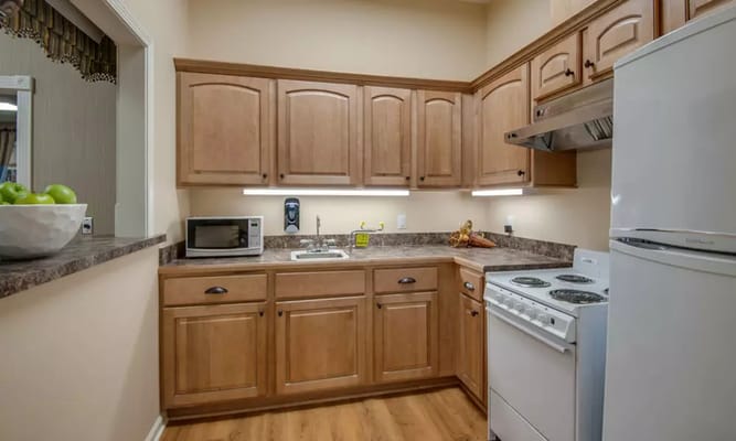 Cozy kitchen with wooden cabinetry and appliances