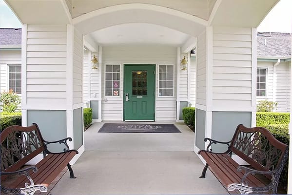Covered entrance with benches and green door