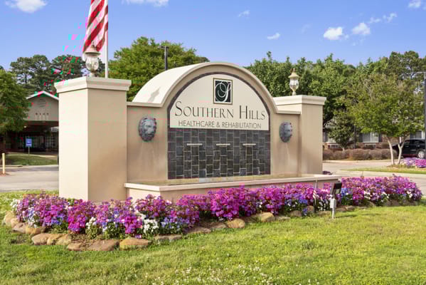Sign for Southern Hills Healthcare and Rehabilitation with flowers in the foreground.