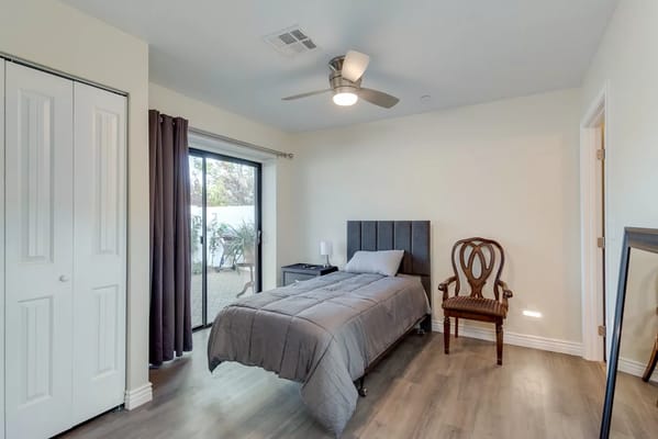 A private resident room with a bed and chair