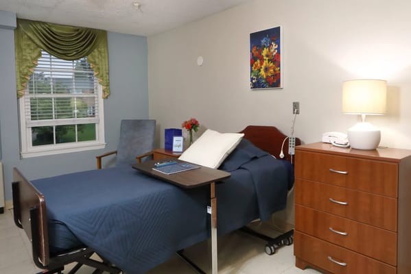 Private resident room with bedside table and window