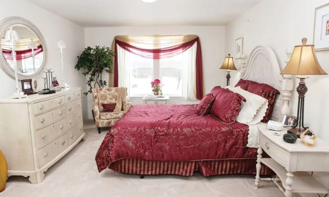 Elegant bedroom with a bed, dresser, and armchair