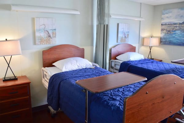Shared bedroom with two beds, bedside tables, and lamps