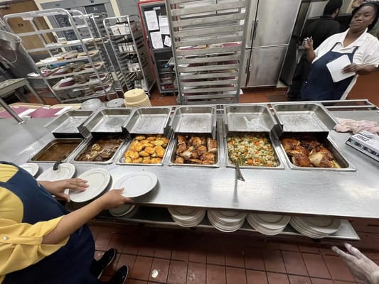 Kitchen staff serving food in a dining area