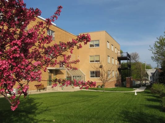 Exterior view of building with blooming trees and lawn