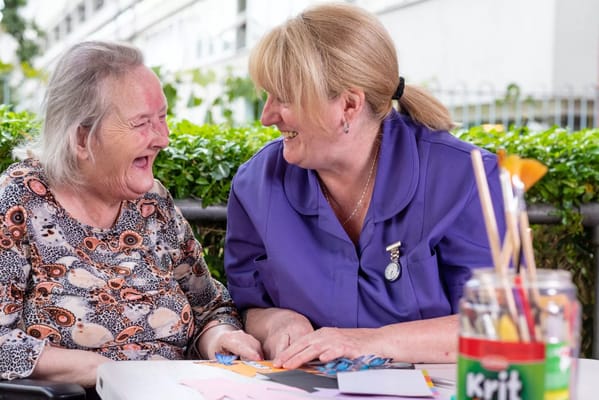 A staff member and resident enjoying an activity together outside
