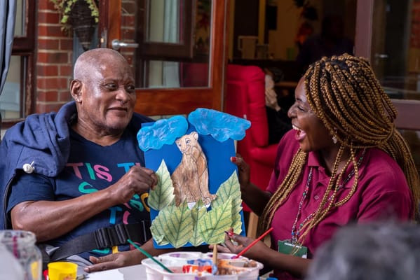 Resident enjoying art activity with staff member