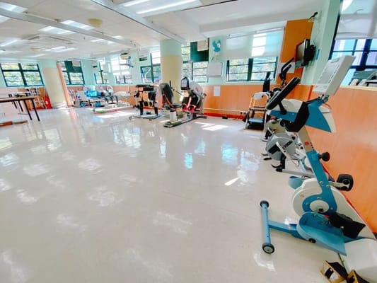 Well-equipped activity room with exercise equipment and bright lighting.