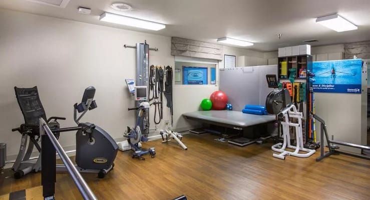 Rehabilitation gym with exercise equipment and therapy tools.