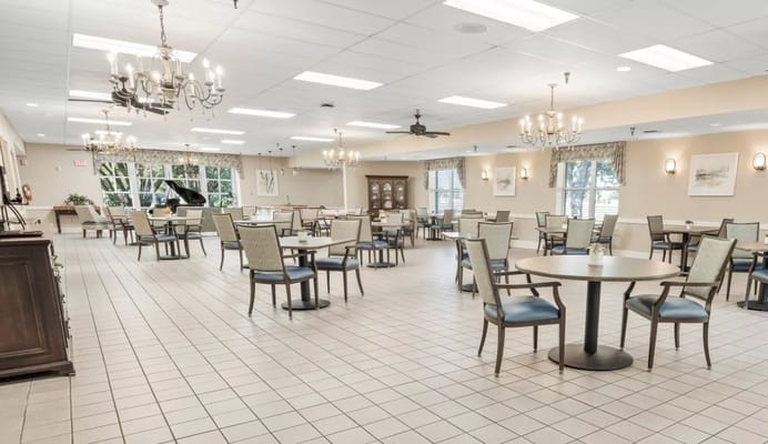 Spacious dining room with tables and chairs at St. Joseph's Assisted Living
