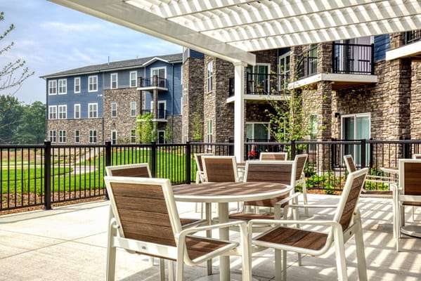 Tables and chairs on the outdoor patio overlooking the building
