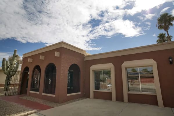 Exterior of Starfish Care Homes with cacti and cloudy skies