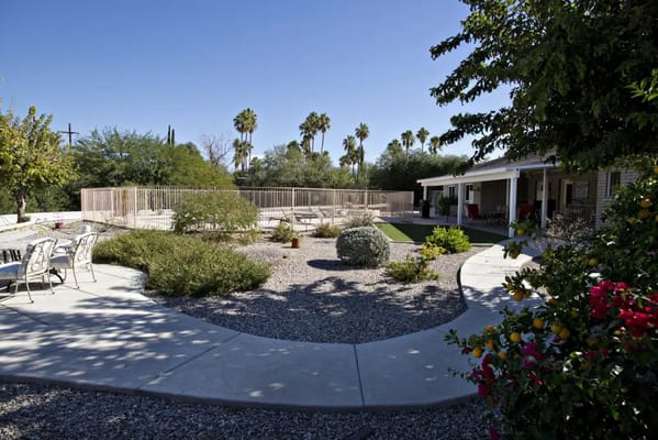 View of the pool area with surrounding landscaping and seating.