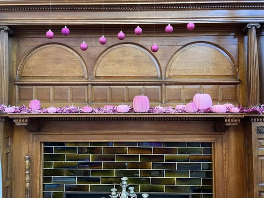 Decorative pink pumpkins and ornaments on a mantel