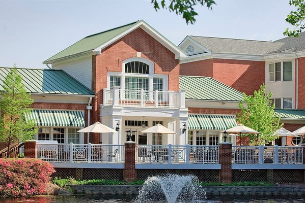 Exterior view of a senior living facility with outdoor seating