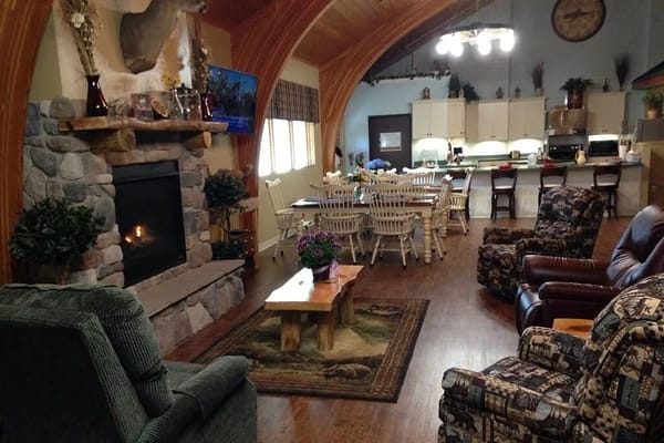 Spacious common area with a fireplace and seating at Stone Lodge Memory Care