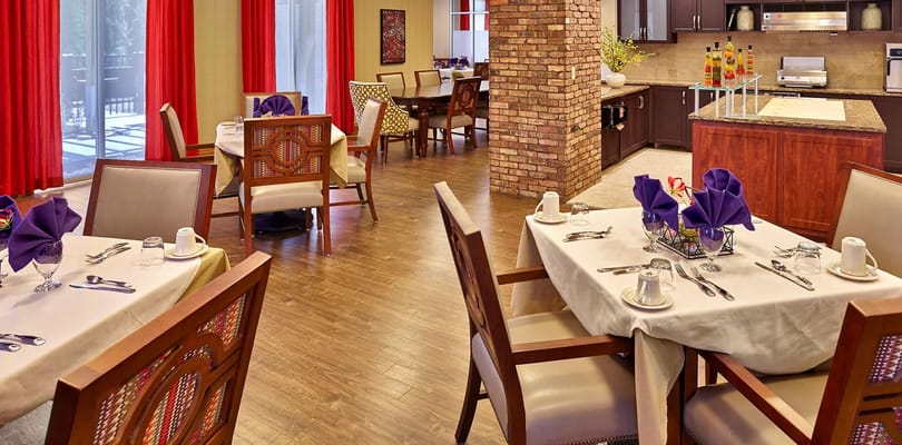 Elegant dining room set up for a meal with purple napkins